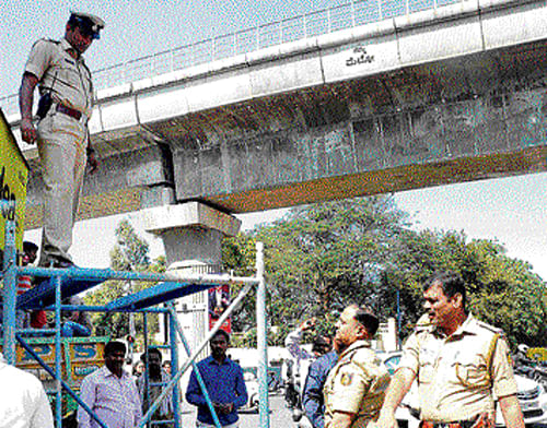 police perch: Police personnel inspect a temporary  watchtower erected to monitor New Year celebrations on  MG Road in the City on Monday. dh photo