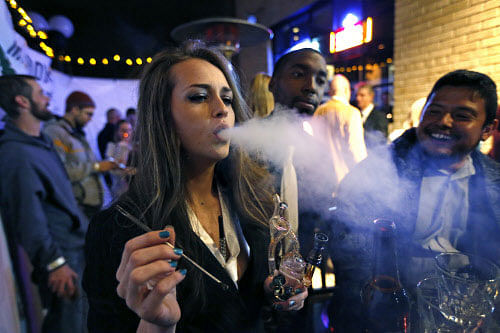Partygoers smoke marijuana during a Prohibition-era themed New Year's Eve party celebrating the start of retail pot sales, at a bar in Denver, late Tuesday Dec. 31, 2013. Colorado is to begin marijuana retail sales on Jan. 1, a day some are calling 'Green Wednesday.' AP photo