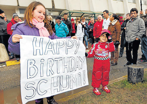 In the hearts of millions: Kids hold a banner wishing Michael Schumacher Happy  Birthday as the German continues his recovery at a hospital in Grenoble, France. Reuters
