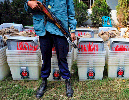A member of the police stands guard in front of ballot boxes at a distribution centre ahead of parliamentary elections in Dhaka January 4, 2014. Nearly 60 polling stations in Bangladesh were set on fire and three people were killed on the eve of Sunday's election in which the ruling Awami League looks certain to prevail in a walkover as the main opposition party boycotts the poll. REUTERS