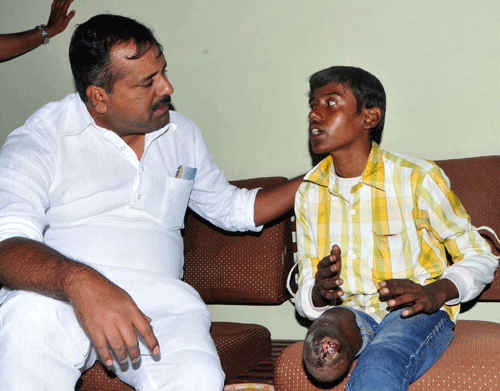 Physically challenged Shivaramu seeks help from Health and Family Welfare Minister U T Khader at Circuit House in Mangalore on Saturday. DH Photo