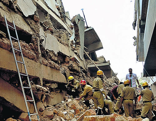 Rescue workers stand amid the debris of a building that  collapsed on Saturday at Canacona near Panaji. AP