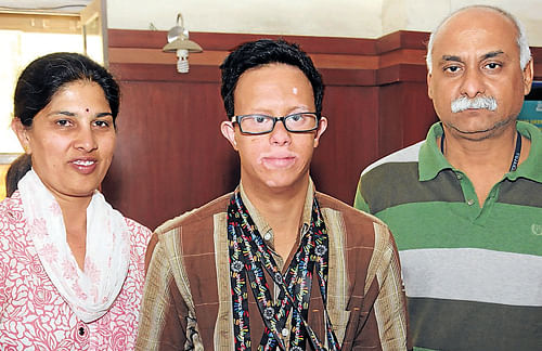 Anand (centre) poses with the medals along with his parents Chaya  and Sudesh. DH Photo
