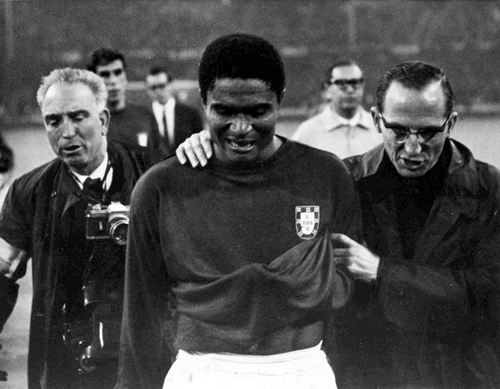 In this July 26, 1966 file photo, Portugal's star player Eusebio is led from the pitch in tears after England defeated Portugal 2-1 in the semifinal of the World Cup at Wembley, London. Eusebio, the Portuguese football star who was born into poverty in Africa but became an international sporting icon and was voted one of the 10 best players of all time, has died of heart failure aged 71, Sunday, Jan. 5, 2014. AP Photo