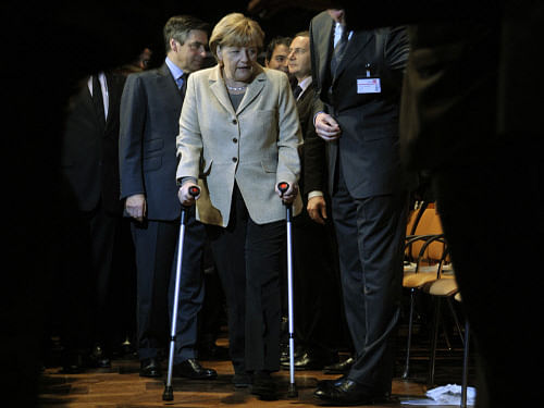 File photo of German Chancellor Angela Merkel, on crutches, and France's Prime Minister Francois Fillon (L) attend the opening ceremony of the 'Hannover Messe' industrial trade fair in Hanover April 3, 2011. German Chancellor Angela Merkel has fractured her pelvis in a cross-country skiing accident and is walking with the help of crutches, forcing her to call off some foreign visits and official appointments, her spokesman said January 6, 2014. Merkel fell while skiing over the Christmas vacation. What she first thought was heavy bruising turned out to be a partial fracture, meaning she must take it easy for three weeks and work from home where possible, said her spokesman Steffen Seibert. REUTERS