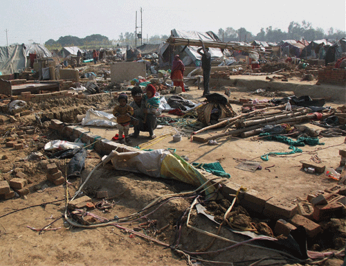 People search for their articles after Uttar Pradesh government removed tents at a relief camp housing the victims of Muzaffarnagar riots in Loi village on Saturday. PTI File Photo