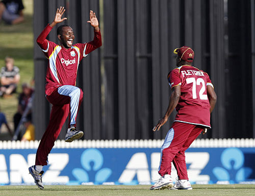 West Indies' Nikita Miller, left, and Andre Fletcher celebrate taking a New Zealand wicket during their one day international cricket match in Hamilton, New Zealand, Wednesday, Jan. 8, 2014. AP  photo