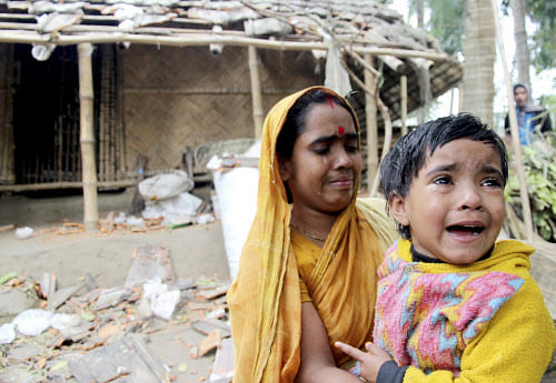 Bipasa Barman, 4, cries as her mother Sanchita Barman looks on in front of their vandalized house after Bangladesh Jamaat-E-Islami activists attacked a Hindu village in Jessore in this picture provided by Prothom Alo January 6, 2014. Reuters.
