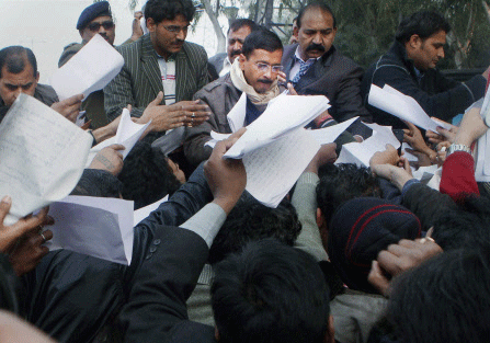 Delhi Chief Minister Arvind Kejriwal collecting papers regarding people's grievances during his inaugural 'Janata Darbar' or public hearing at Delhi Secretariat in New Delhi on Saturday. PTI Photo