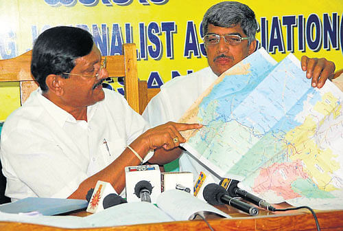 Former minister B Shivaramu explains about Yethinahole water project, in Hassan, on Monday. District Congress vice-president Narayana Gowda is seen. DH Photo