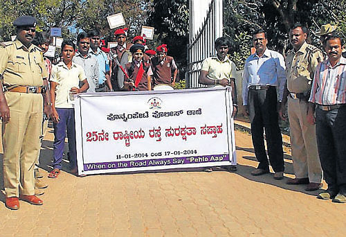 Circle Inspector P K Raju, Government College Principal Shivalinga Shetty, Sub-Inspector Shivalingaiah and others take part in the 25th road safety jatha, organised by Police department, at Ponnampet, near Gonikoppa, on Monday. DH Photo