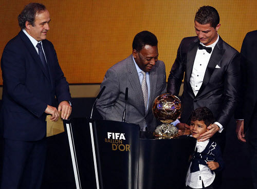 Portugal's Cristiano Ronaldo (R) looks at his son Cristiano Ronaldo Jr with Pele as UEFA President Michel Platini (L) looks on after Ronaldo was awarded the FIFA Ballon d'Or 2013 in Zurich January 13, 2014. Portugal and Real Madrid forward Cristiano Ronaldo was named the world's best footballer for the second time on Monday, preventing his great rival Lionel Messi from winning the award for a fifth year in a row. REUTERS