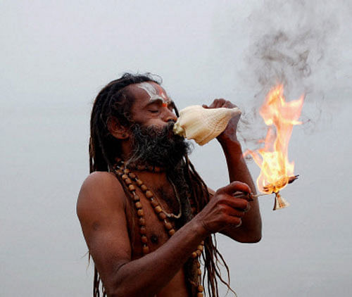 A Hindu priest lights a traditional oil lamp to perform Aarti during the evening prayers on the banks of river Ganges on the occasion of the Makar Sankranti festival in Allahabad / Reuters Image