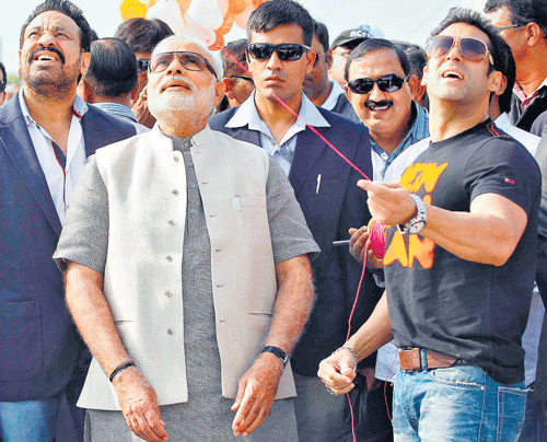 Actor Salman Khan flies a kite as Gujarat Chief Minister Narendra Modi watches in Ahmedabad on Tuesday. Reuters