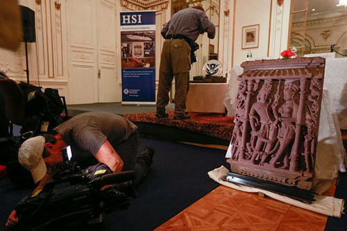 A cameraman videos the 350 pound "Vishnu and Lakshmi" sandstone sculpture, one of three sandstone sculptures stolen from India valued at over $1.5 million. The sculpture was listed as Interpol's top 10 most wanted stolen works of art. Reuters