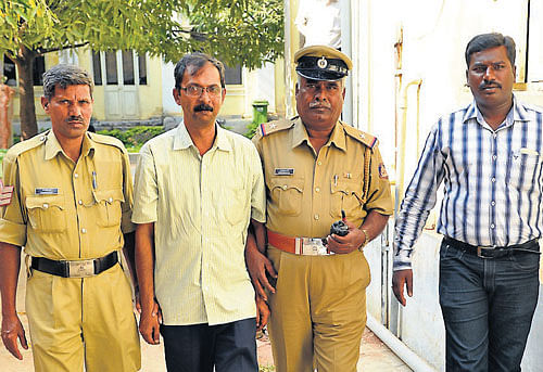 white collar crime: Kuvempunagar police escort dismissed bank manager V&#8200;Vishwanath to a court in Mysore on Thursday. DH Photo