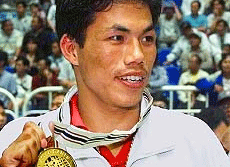 Dingko Singh shows his gold medal during the award ceremony for the 54 kg class boxing final in the 13th Asian Games 1998. Photo courtesy: Indian Navy website