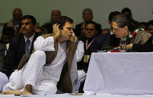 The Congress Party President Sonia Gandhi, right, speaks to her son and Vice President Rahul Gandhi during the All India Congress Committee (AICC) meet in New Delhi on Friday, Jan. 17, 2014. AP