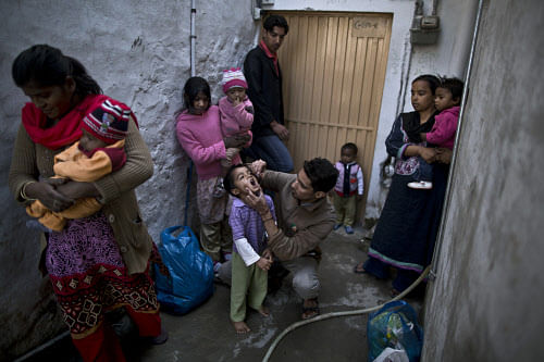 In this file photo taken Monday, Nov. 25, 2013, Pakistani health worker, Nooman Mehboob, 21, center, gives Ameeq Andriaz, 4, a polio vaccine, while other women holding their children wait to have them vaccinated in a neighborhood in Islamabad, Pakistan. The World Health Organization said the northwestern Pakistani city of Peshawar has become the largest poliovirus reservoir in the world. (AP Photo)