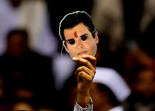 A Congress party member holds up a mask of party Vice President Rahul Gandhi during the All India Congress Committee (AICC) meeting to prepare for the upcoming polls in New Delhi, India, Friday, Jan. 17, 2014. Members of the Congress party erupted in rapturous applause Friday for Rahul Gandhi, heir to the country's Nehru-Gandhi political dynasty, who is leading the struggling party's campaign in the general election in May. (AP Photo/Altaf Qadri)