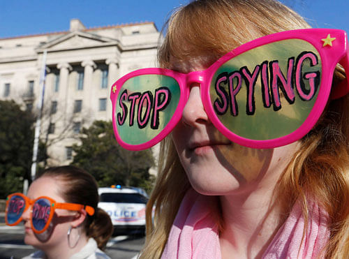 Member of the protest group, Code Pink, Cayman Macdonald protests against U.S. President Barack Obama and the NSA before his arrival at the Department of Justice in Washington, January 17, 2014. Obama banned U.S. eavesdropping on the leaders of close friends and allies on Friday and began reining in the vast collection of Americans' phone data in a series of reforms triggered by Edward Snowden's revelations. REUTERS