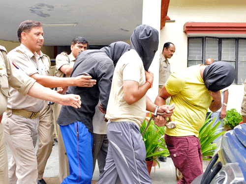 Police escort men (face covered) accused of a gang rape, outside a police station in Noida. Reuters file photo
