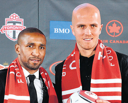 Michael Bradley (right) and Jermaine Defoe pose for  photographs after signing up with Toronto FC in Major Soccer League. Reuters