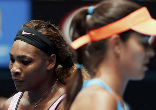 Serena Williams (L) of the U.S. passes Ana Ivanovic of Serbia during a change of ends in their women's singles match at the Australian Open 2014 tennis tournament in Melbourne January 19, 2014. REUTERS