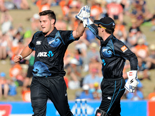 New Zealand's Mitchell McClenaghan, left, gives high five with New Zealand's Luke Ronchi after dismissing India's Rohit Sharma for 3 in the first one-day international cricket match at McLean Park in Napier, New Zealand, Sunday, Jan. 19, 2014. (AP Photo)