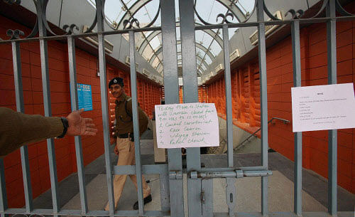 Security personnel closing the gate of Central Secretariat metro station in New Delhi on Monday. Several metro stations were closed due to AAP dharna. PTI Photo
