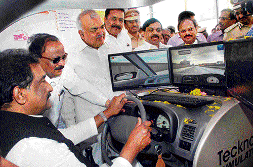 Let me try: Home Minister K J George gets a hands-on experience of the driving simulator at the 25th Road Safety Week in the City on Tuesday. Infrastructure Development Minister  R Roshan Baig, Transport Minister Ramalinga Reddy,  MLC K Govinda Raju, Transport and Road Safety Commissioner K Amaranarayana, Bangalore Police Commissioner Raghavendra H Auradkar look on. dh Photo