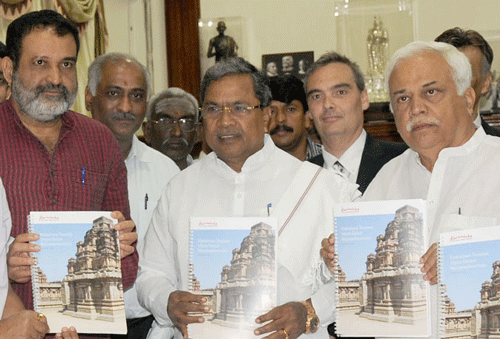 Mohandas Pai, head of the Karnataka Tourism Vision Group, Chief Minister Siddaramaiah, Minister for Higher Education and Tourism R V Deshpande with the Vision Group report in the City on Tuesday.