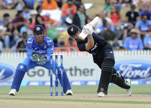 New Zealand's Kane Williamson, right, hits a boundary in front of India's wicketkeeper MS Dhoni in the second one-day International cricket match at Seddon Park in Hamilton, New Zealand, Wednesday, Jan. 22, 2014. (AP Photo)