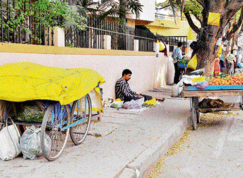Hindrance: Vendors take half the space on the pavements leaving no room for pedestrians.  DH Photos by BK Janardhan