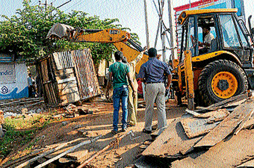 An earthmover belonging to MCC&#8200;removes a petty shop near&#8200;RTO&#8200;east office, in Mysore, on&#8200;Wednesday. dh photo