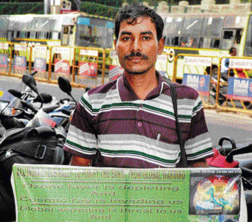 Ram Prasad Naskar with his eco-awareness banner. DH Photo