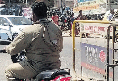 Illegal: A police official seen riding without the helmet in the City.