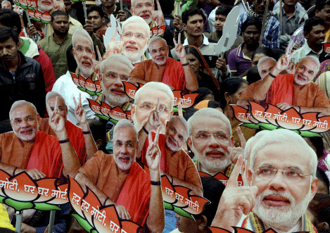 BJP workers display cut-outs of Narendra Modi as they take part in party's nation-wide 'Modi for PM' and 'Ek Note-Kamal Par Vote' campaign in Bhopal on Thursday. PTI Photo