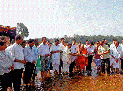 Odiyur seer Gurudevananda Swamy among others pour milk to River Nethravathi.  DH Photo