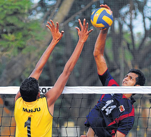 Postal A Karthik (right) smashes past BSNL's Manjunath in the Karnataka Volleyball League. DH&#8200;Photo
