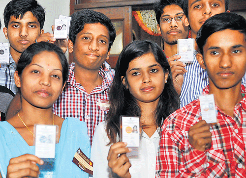 First-time voters exhibit their election ID cards distributed by Governor H R Bhardwaj on the National Voters Day in Bangalore on saturday. DH Photo