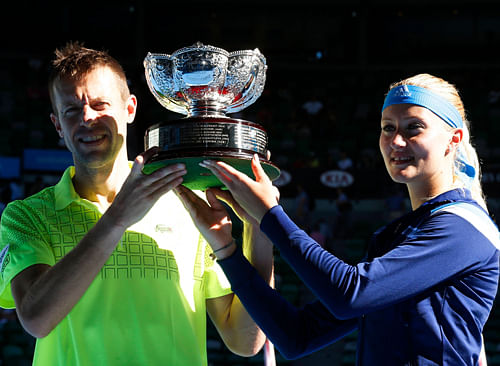 Kristina Mladenovic of France and Daniel Nestor of Canada pose with the trophy after defeating Horia Tecau of Romania and Sania Mirza of India in their Mixed Doubles final match at the Australian Open 2014 tennis tournament in Melbourne January 26, 2014. REUTERS