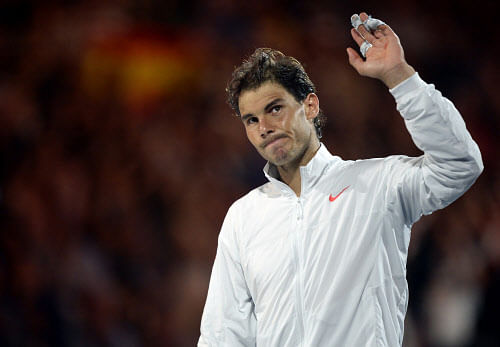 Rafael Nadal of Spain waves to the spectators during the trophy presentation after his loss to Stanislas Wawrinka of Switzerland in the men's singles final at the Australian Open tennis championship in Melbourne, Australia, Sunday, Jan. 26, 2014. (AP Photo)