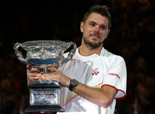 Stanislas Wawrinka of Switzerland holds the trophy after defeating Rafael Nadal of Spain during the men's singles final at the Australian Open tennis championship in Melbourne, Australia, Sunday, Jan. 26, 2014. (AP Photo)
