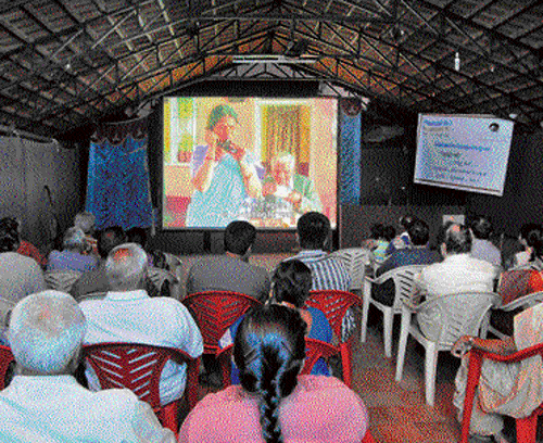 People watch a Kannada film at the rooftop of actor Srinath  Vasistha's house in Vijayanagar. DH Photo