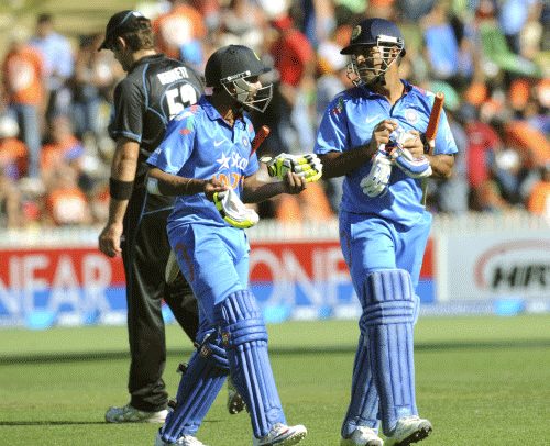 Ravindra Jadeja, left, and MS Dhoni leave the pitch at the end of their innings of 278 against New Zealand during their fourth one-day international cricket match, at Seddon Park, in Hamilton, New Zealand, Tuesday, Jan. 28, 2014. AP photo