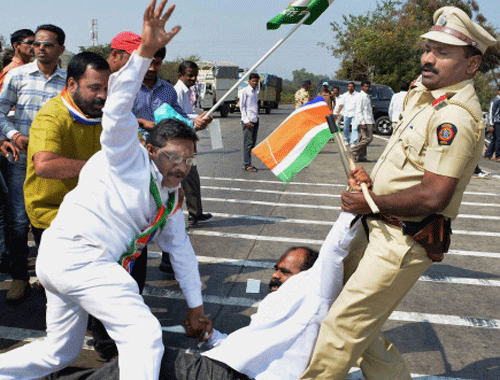 A police officer drags MNS workers who were protesting on Pune-Bangalore National Highway in Karad, Maharashtra, on Tuesday. PTI