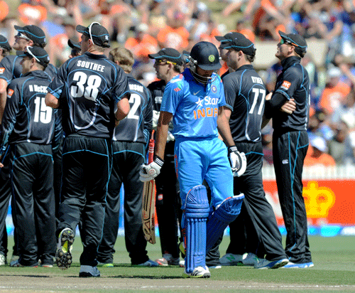 Rohit Sharma walks out for 79 as the New Zealand team watch the replay of the dismissal on the big screen in the fourth one-day international cricket match at Seddon Park in Hamilton, New Zealand, Tuesday, Jan. 28, 2014. AP