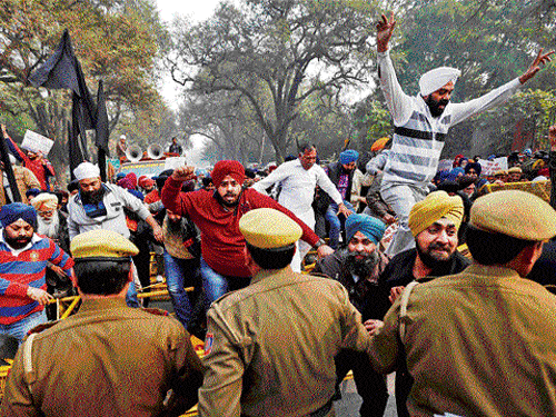 In Protest: People break a barricade as they protest against Congress party Vice President Rahul Gandhi for his remark on the 1984 anti-Sikh riots in New Delhi on Thursday. PTI