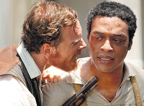The Banality of evil: Edwin Epps (Fassbender) uses his stature and the point of a gun to bully Northrup (Ejiofor).